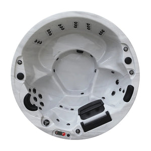 Overhead photograph of an empty, round hot tub with a marbled white interior shell. Multiple black hydrotherapy jets line the interior seating alcoves, and a digital control panel with a red border is mounted on the bottom rim alongside integrated black filters and headrests.