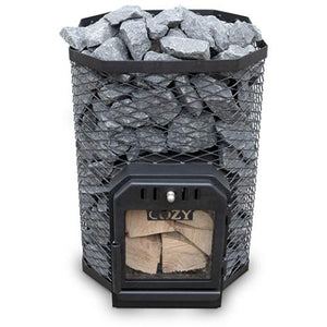 A Cozy Heat 18kW wood-burning sauna stove is shown from a front perspective against a plain white background. The stove features a multi-sided, octagonal outer cage made of black wire mesh that is filled to the top with grey sauna stones. A black cast-iron firebox door is integrated at the base, featuring a large glass viewing window that reveals stacked pieces of firewood inside the chamber and the "COZY" brand name visible just above the wood.