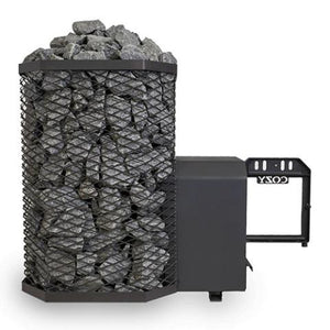 A Cozy Heat 18kW Thru-Wall wood-burning sauna stove is shown from a side perspective against a plain white background. The left portion of the unit features the tall, octagonal black wire mesh cage packed to the top with grey sauna stones. Extending horizontally to the right is the structural firebox tunnel designed for through-wall installation, ending with the open frame of the black cast-iron door that features the embossed "COZY" brand name.