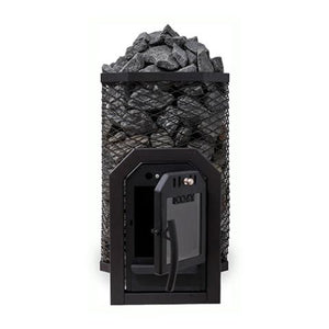 A Cozy Heat Thru-Wall wood-burning sauna stove is shown from a front perspective against a plain white background. The stove features a tall, octagonal black wire mesh cage packed to the top with textured grey sauna stones. At the front base, the structural firebox tunnel designed for through-wall installation is visible, featuring a black cast-iron frame with its glass-windowed door swung wide open to the right to reveal the dark interior chamber.