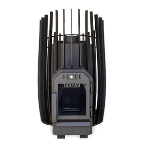 A front, straight-on view of an empty black metal sauna stove against a white background. The barrel-shaped body is shown without rocks, revealing a solid inner heating chamber surrounded by a tall outer cage of vertical rectangular slats that rise into a peaked, crown-like pattern at the top. The dark grey firebox door at the bottom center features a dark, unlit square glass window under the embossed logo 'COZY'.