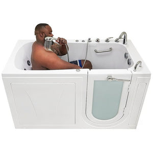 White walk-in bathtub with a man seated inside using the handheld shower, low entry threshold, built-in grab bar, hydrotherapy jets, and chrome control faucet, viewed from the side.