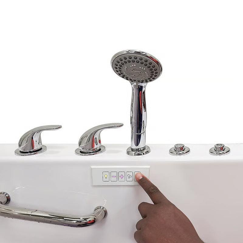 Close-up of a hand pressing a button on the control panel of a white walk-in bathtub, with chrome handheld shower, faucet handles, and grab bar visible.