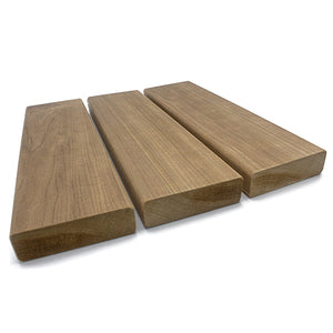Three rectangular wood planks arranged side by side from a low, three-quarter perspective, displaying their smooth top faces, rounded edges, and textured cross-section end grain in the foreground.