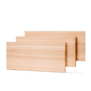 Three rectangular light-colored wood boards standing vertically and staggered slightly behind one another against a white background, showing their horizontal grain lines.