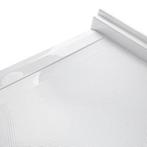 A close-up, angled view of the corner of a white acrylic shower base. The image highlights a detailed, slip-resistant textured pattern on the floor surface consisting of small, raised dots. It also shows the smooth, glossy finish of the integrated tiling flange and the raised outer edge of the base.