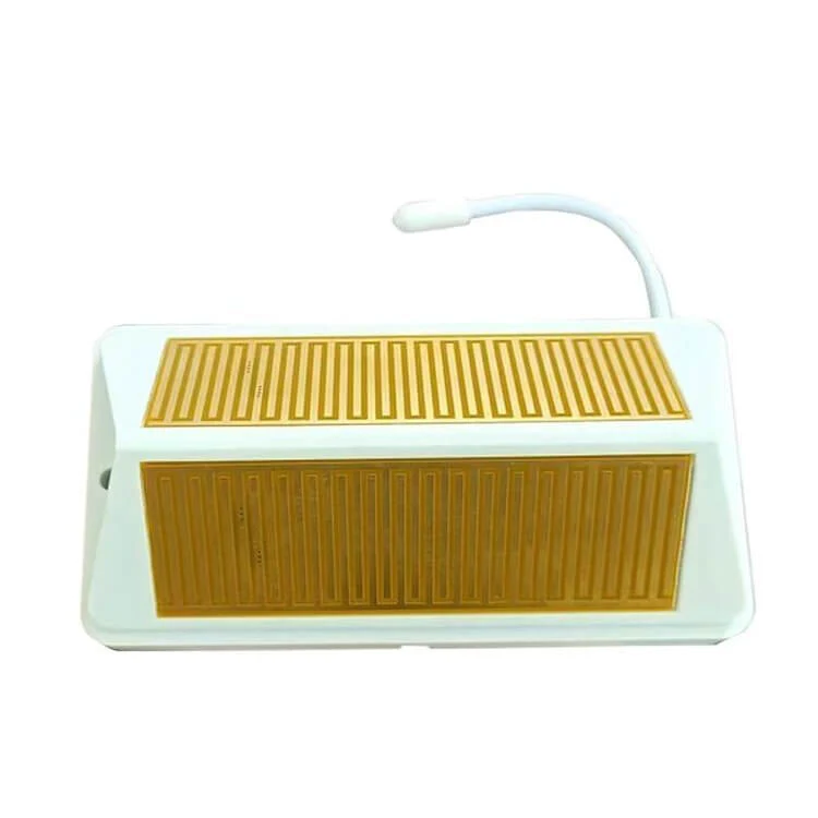 A white electronic sensor module sits horizontally on a plain background, featuring two distinct gold-colored, zigzagging grid patterns across its angled front panels and a short white wire curving out from the top.