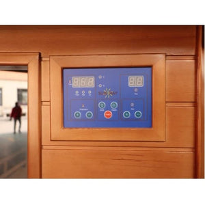 A close-up shot of a digital control panel embedded in the exterior wooden wall of a sauna, featuring a blue interface with digital displays, indicator lights, touch buttons, and the SunRay logo.