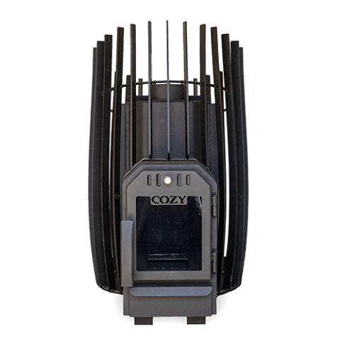 A front, straight-on view of an empty black metal sauna stove against a white background. The barrel-shaped body is shown without rocks, revealing a solid inner heating chamber surrounded by a tall outer cage of vertical rectangular slats that rise into a peaked, crown-like pattern at the top. The dark grey firebox door at the bottom center features a dark, unlit square glass window under the embossed logo 'COZY'.