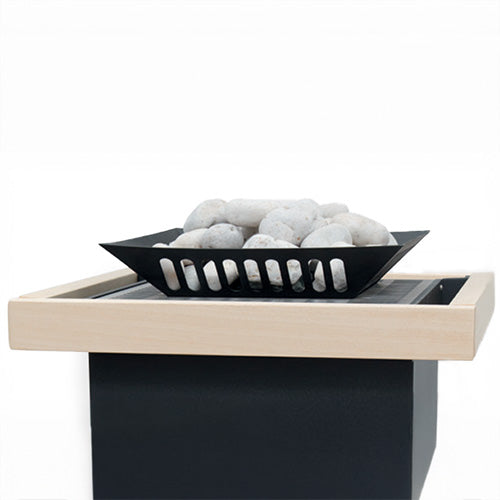 White sauna stones in black slotted basket on top of heater with light wood frame.