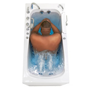 White walk-in bathtub with a man seated inside using active hydrotherapy jets, dual chrome faucets, and grab bar, viewed from above.