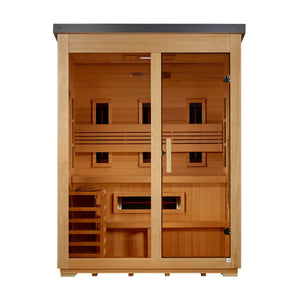 A straight-on front view of a light-tan wooden sauna cabin with a dark gray roof. The glass front has a fixed window on the left and a glass door on the right with a wooden handle. Inside, dark infrared heater panels with glowing red center lines are built into the walls: three vertical panels line the back wall behind a slatted backrest, one horizontal panel is under the two-tier bench, and three square panels line both side walls. A wooden heater cage sits on the bottom left.