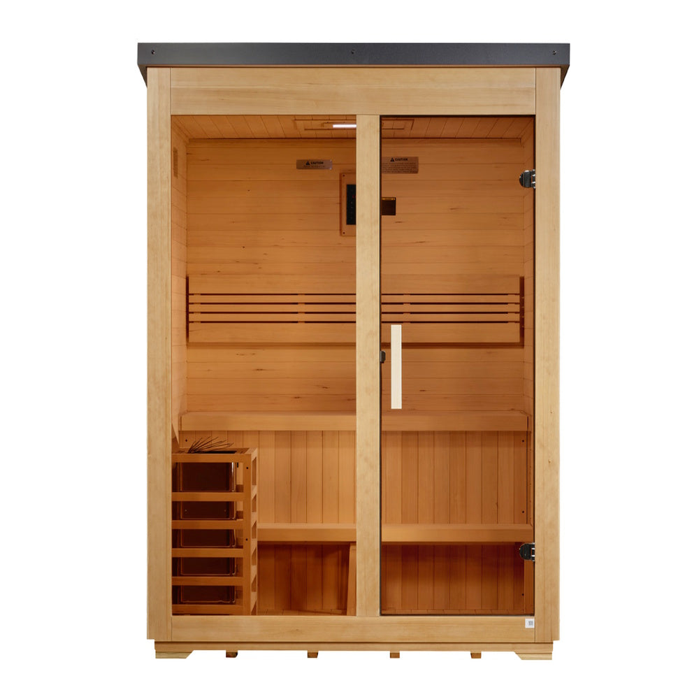 A straight-on, eye-level view of the same rectangular wooden sauna cabin. The front features two symmetrical halves: a fixed glass pane on the left and a glass door on the right with a vertical wooden handle and dark metal hinges. Inside, horizontal light-tan wood planks line the walls. A two-tier bench spans the width, backed by a horizontal slatted backrest. On the bottom left sits a small wooden-slat cage enclosing a heater. A digital panel and small warning labels are centered on the upper back wall.