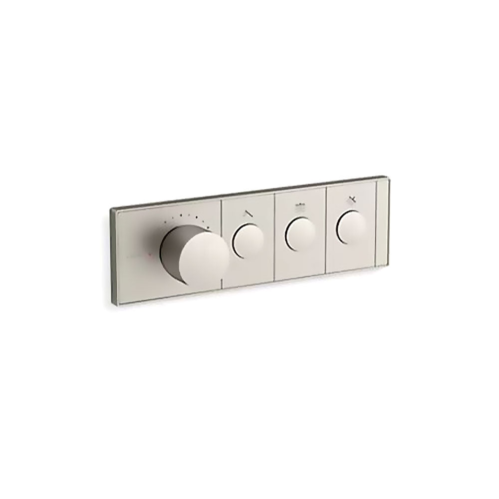 A horizontal, rectangular Kohler K-26347-9 Anthem mechanical thermostatic valve control in brushed nickel, angled slightly right against a white background. The sleek faceplate features four cylindrical knobs in a row. The first knob on the left is much larger and thicker, surrounded by small indicator dots for temperature. To its right are three smaller, identical control knobs, each centered within a rectangular segment containing a small icon above it.