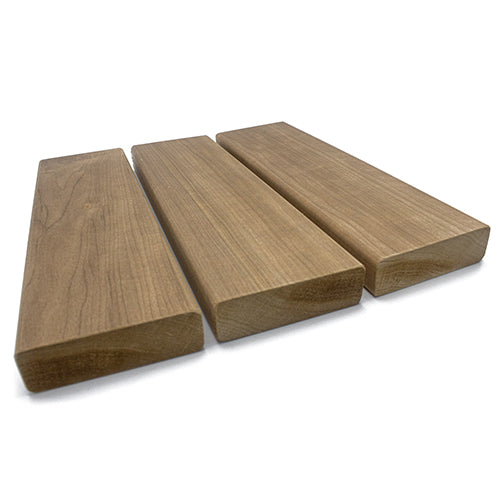 Three rectangular wood planks arranged side by side from a low, three-quarter perspective, displaying their smooth top faces, rounded edges, and textured cross-section end grain in the foreground.