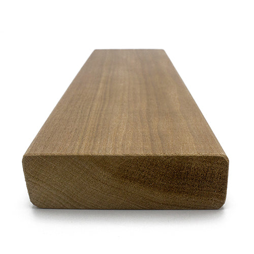 A rectangular wood plank viewed from a low-angle perspective, displaying the cross-section end grain in the foreground and the long face extending backward.