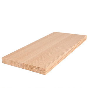 A rectangular light-colored wood board laying flat on a white surface, shown from an elevated diagonal angle to display its top face, side edge, and rough end grain.