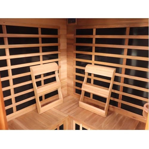 An interior perspective of the SunRay Sauna Bristol Bay Indoor FAR Infrared Corner Sauna (model HL400KC_4), showing the upper bench seating arrangement with two ergonomic wooden backrests mounted against the wood-paneled walls and black infrared heating panels behind horizontal slat guards.