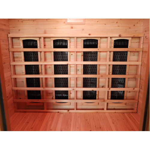 The interior of the sauna features warm-toned wooden paneling and flooring, highlighted by a wide slatted wooden backrest mounted against the wall that houses four vertical black infrared heating panels.