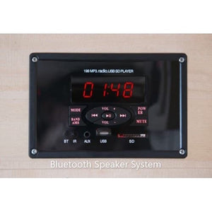 A close-up shot of a rectangular Bluetooth speaker system panel mounted flush on light wood. The black glossy control panel features a central red digital display showing '01:48', control buttons for mode, volume, track skipping, and power, along with small indicator labels for Bluetooth, an IR sensor, an AUX port, a USB port, and an SD card slot.