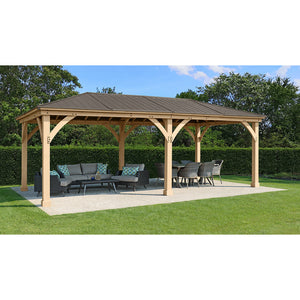 12 x 24 Meridian Gazebo - exterior grade cedar coated in natural cedar-color stain with coffee brown colored aluminum roof, 6” x 6” Posts with classic plinths, Heavy, curved corner gussets placed in a garden isometric view
