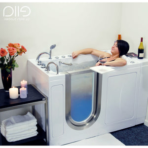 A woman relaxing in a Ella Elite 30"x52" Acrylic Soaking + Heat Walk-In Bathtub with Brushed stainless steel and frosted tempered glass door and Left Swing Door, 2 Piece Fast Fill Faucet, 2" Dual Drain, 2 overflows, two 5 ft. incoming supply lines and 2 drain elbows, 2 stainless steel grab bars, 360° swivel tray, Detachable wide backrest in a white background