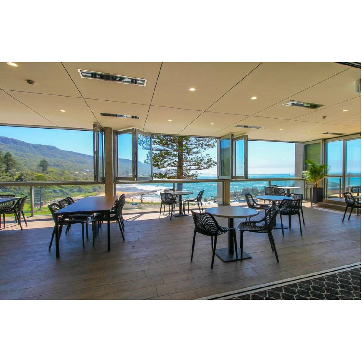 2300W Platinum Smart-Heat Electric Heater in Black Stainless Steel Tinted Glass-Ceramic Screen Slim-line Design mounted in ceiling of a dining set