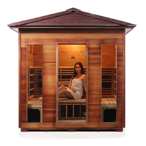 Rustic infrared sauna Canadian red cedar with peak roof and glass door and window side rear view with young woman model inside front view